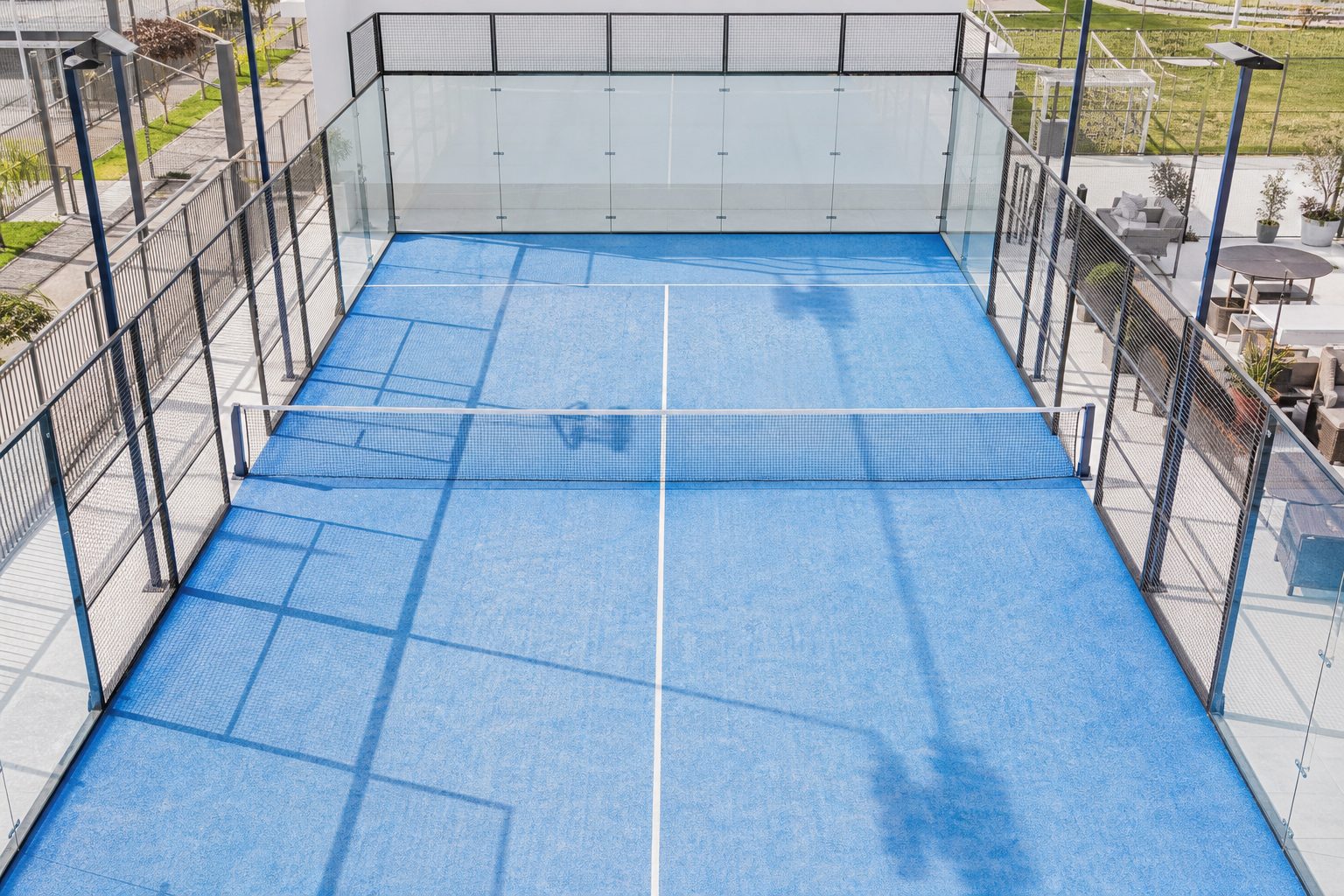 Campo da basket all'aperto con linee bianche dipinte, davanti a un edificio residenziale.